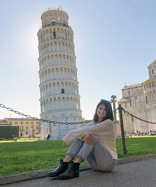 SBU student sitting with the leaning Tower of Pisa in the background