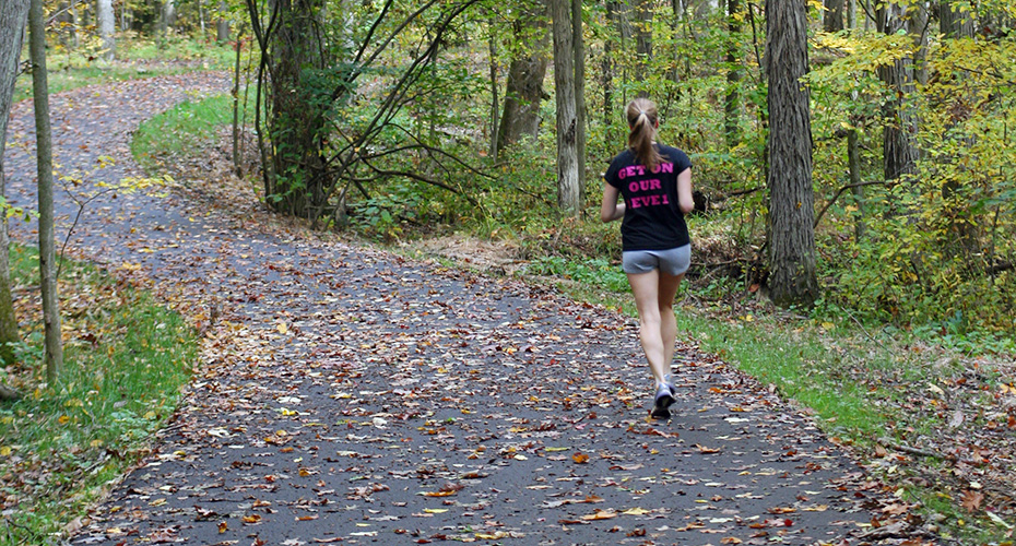A female student running on the Allegheny River Valley Trail