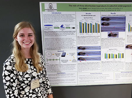 Erin McNell stands in front of her research poster