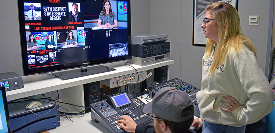 Students watching monitors while producing a news show for SBU-TV