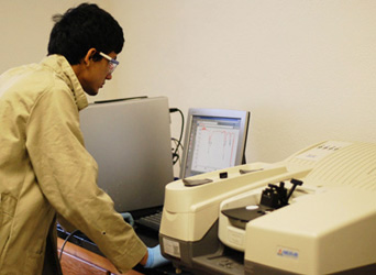 A student stands in front of the FT-IR.