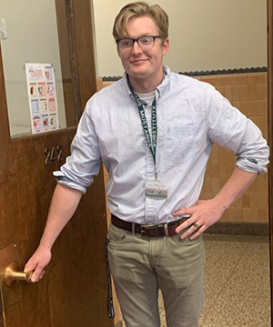 Charlie stands next to a classroom.