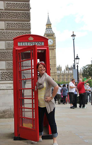 Student playfully entering at a phone booth outside Big Ben