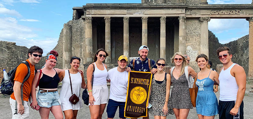 Sorrento program participants holding a Bonaventure banner on a visit to Pompeii