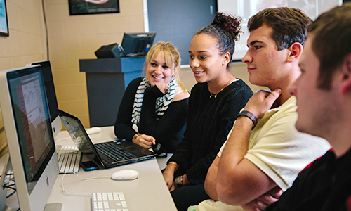 Students gathered around a computer screen