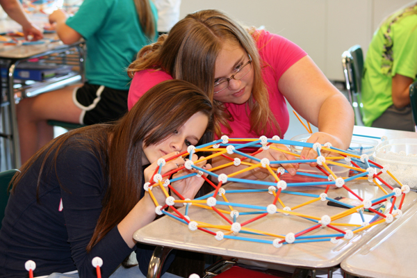 ...and then connect them to complete the module. Two students work together to complete a module.