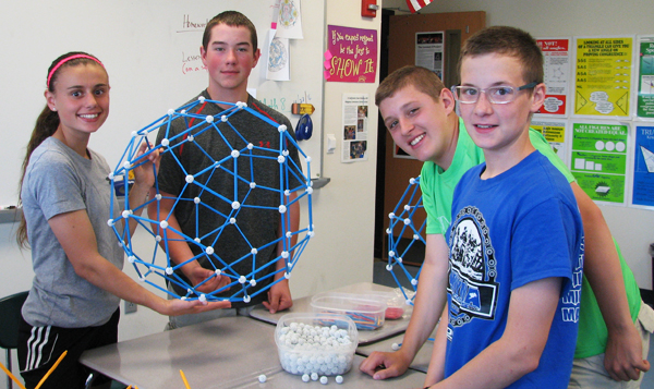 Four students show the center module of the structure.