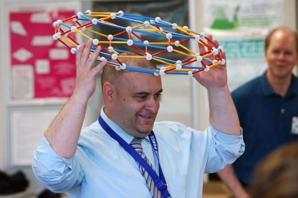 Principal Pecorella puts a module on his head.