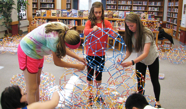 Taylor, Chloee, and Ryleigh put the center module in place.
