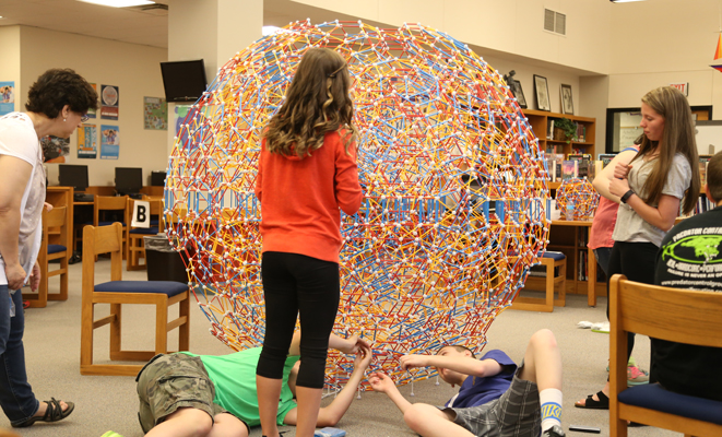 The structure was taller than everyone working on it. Students work all around the structure.