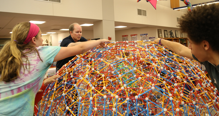 Taylor, Dr. Hill, and Brandon work together to complete the top. Taylor, Dr. Hill, and Brandon work together to complete the top.