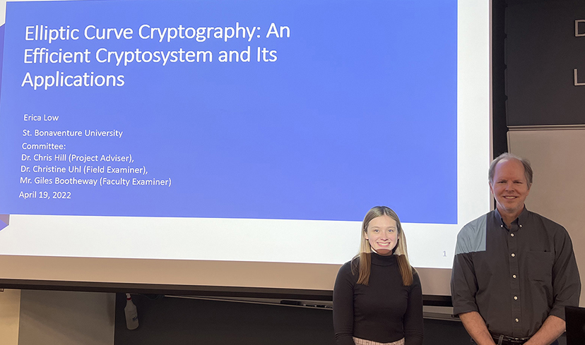 Erica Low and Dr. Hill stand in front of a screen with Erica's title slide.