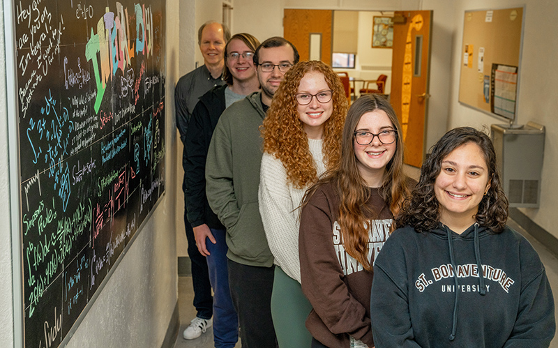 Dr. Hill's fall 2022 Calculus II class poses with the Integral Day display that they decorated.