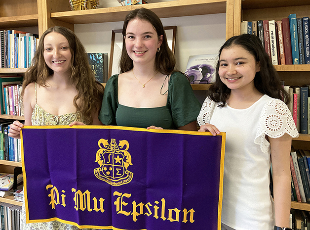 Three of the new inductees pose with the PME banner