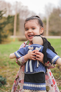 A Seneca child holding her doll