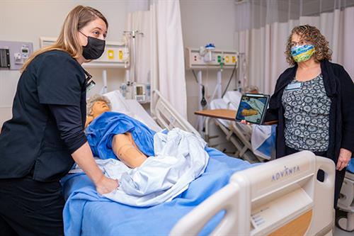 MEP photo Nursing instructors using an iPad to convey a lesson on patient care.
