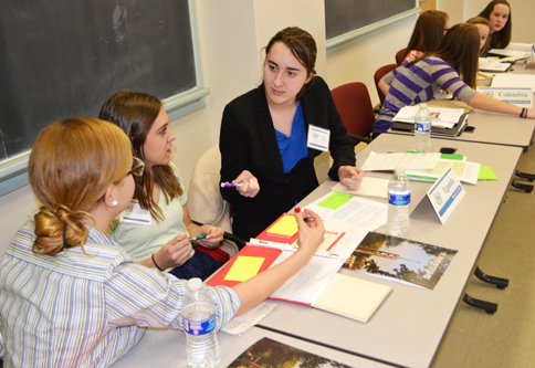 Three women sit at a table and confer.