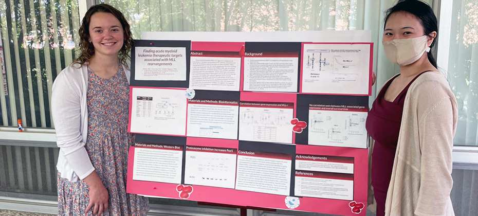 Two students with a research poster