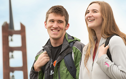 Two students laughing as they chat on campus