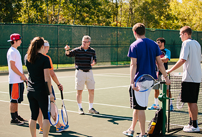 Students on outdoor tennis courts on campus