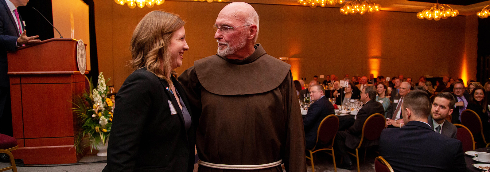 SBU&#39;s Fr. Dan Riley greets a guest at the Gaudete Awards event