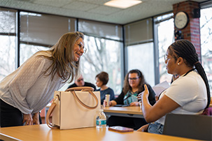 Teacher and student discuss ideas in classroom.