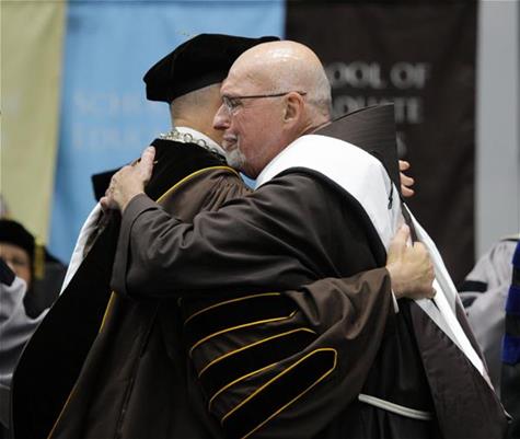 Fr. Dan (right) hugs President Gingerich