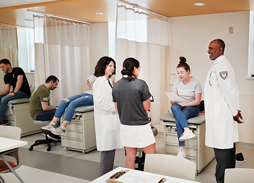 Kesha Steighner and Derien Braxton, assistant professors of Physician Assistant Studies, conduct a skills lesson with students in Francis Hall. physician assistant students and faculty