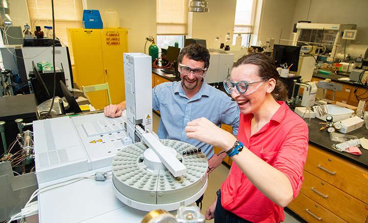Dr. Scott Simpson looks on as Katharina “Katie” Heitzman, ’22, a dual chemistry/biochemistry major uses a gas chromatograph – mass spectrometer (GC-MS) to identify compounds in the university’s Chemistry Instrumentation Suite. Dr. Scott Simpson looks on as Katharina “Katie” Heitzman, ’22, a dual chemistry/biochemistry major uses a gas chromatograph – mass spectrometer (GC-MS) to identify compounds in the university’s Chemistry Instrumentation Suite.