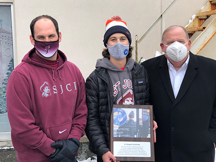 Dr. Dennis DePerro presents a plaque to Food Basket President Kyle DiNicolantonio, '21, and social studies teacher Michael Stewart plaque presentation